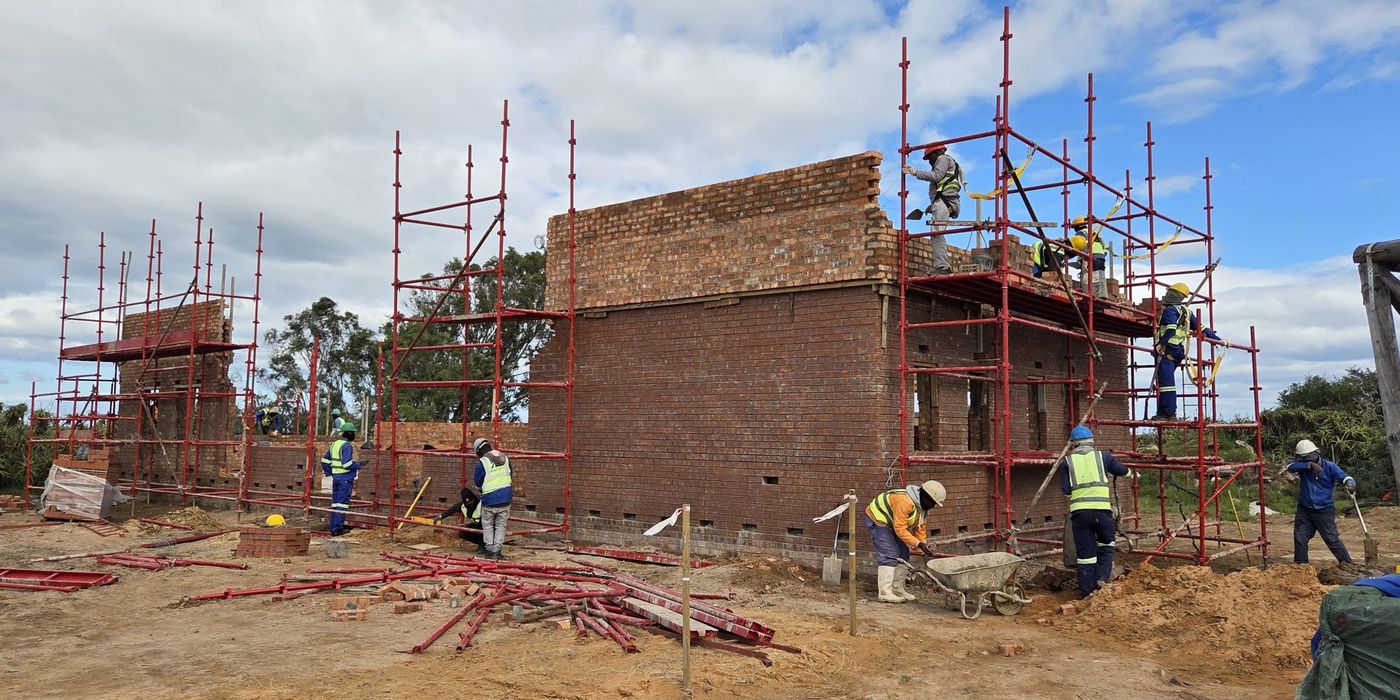 Construction workers building a brick structure on scaffolding